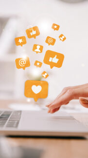 cropped view of businesswoman typing on laptop at workplace with multimedia icons cropped view of businesswoman typing on laptop at workplace with multimedia icons