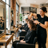 A23_A skilled hairdresser styling a client's hair in a bright modern salon